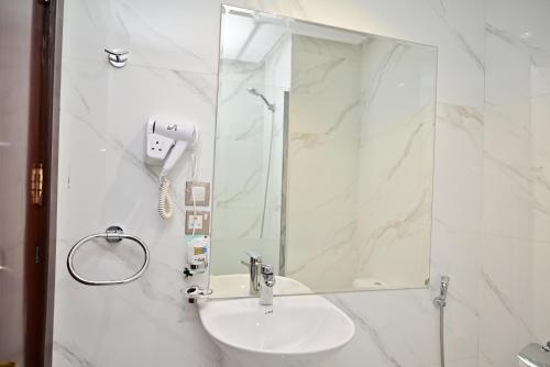 a white bathroom with a sink and a mirror at فندق أورنسيس الحرم in Mecca