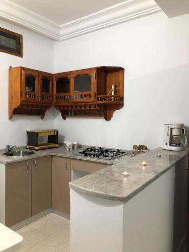 a kitchen with wooden cabinets and a counter top at Une belle maison à houmet souk in Houmt Souk