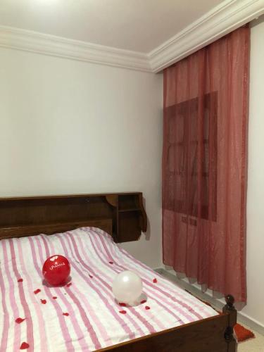 1 dormitorio con 1 cama con sábanas de rayas rojas y blancas en Une belle maison à houmet souk, en Houmt El Souk