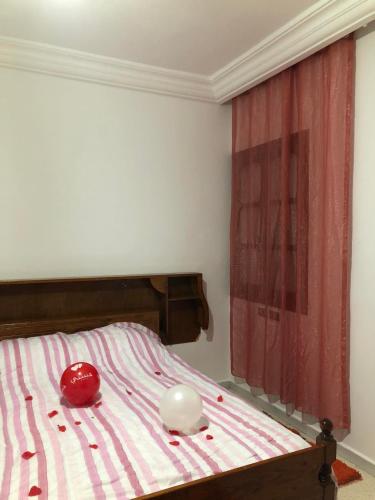 - une chambre dotée d'un lit avec des draps rayés rouges et blancs dans l'établissement Une belle maison à houmet souk, à Houmt Souk