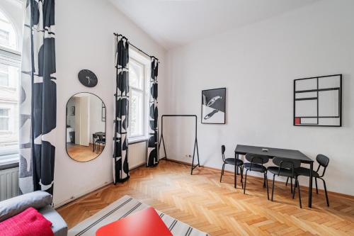een woonkamer met een tafel en stoelen en een spiegel bij Charmante Stadtwohnung in Wenen