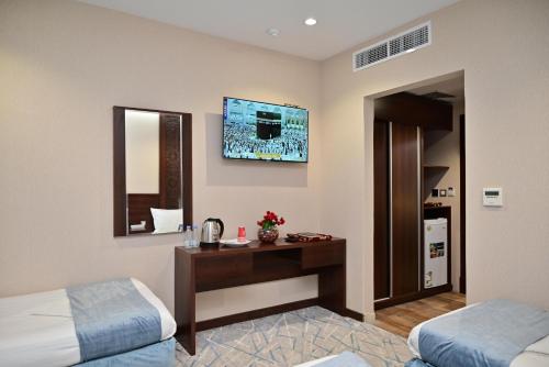 a hotel room with two beds and a desk and a mirror at فندق أورنسيس الحرم in Mecca