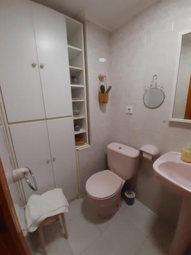 a white bathroom with a toilet and a sink at Casa cerca de la playa en Somo in Somo