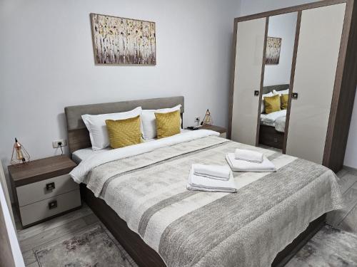 a bedroom with a large bed with yellow pillows at Tei Residence in Piatra Neamţ