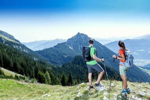 dos personas de pie en la cima de una colina mirando las montañas en Chalets Grossmitt, en Pertisau
