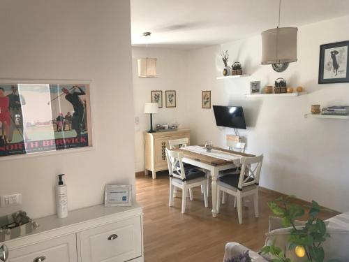 uma sala de estar com uma mesa de jantar e uma secretária em Appartamento Verde Golf em Miglianico