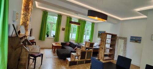 ein Wohnzimmer mit grünen Vorhängen und einem Sofa in der Unterkunft Modernes Wohnen am See in Schwerin