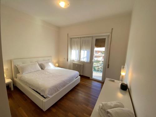 a white bedroom with a bed and a window at Diamond Apartment in Rome