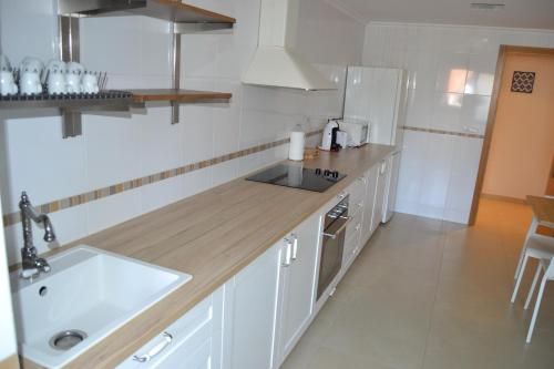 a white kitchen with a sink and a counter at Touristhome Frei Luis in Sarria