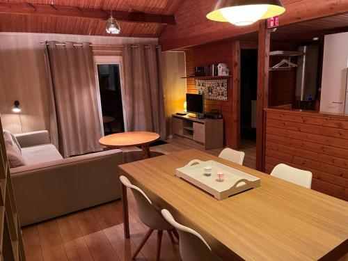 Chalet 182 La Boverie Rendeux - La Roche في ريندو: غرفة معيشة مع طاولة وأريكة