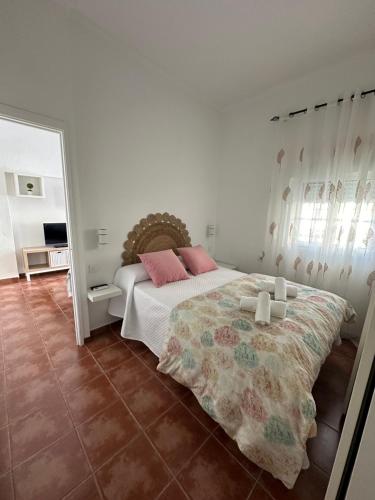 um quarto com uma cama com almofadas cor-de-rosa e um espelho em Apartamento Entre dos mares em Tarifa