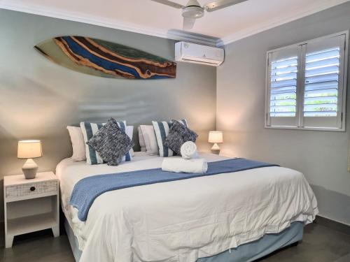 a bedroom with a large white bed and a window at 77 Chaka's Cove in Ballito