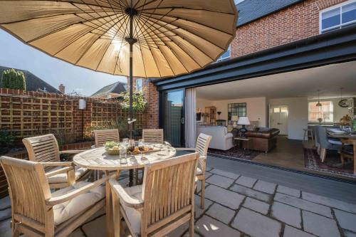 a patio with a table and chairs and an umbrella at Seabiscuit in Lymington