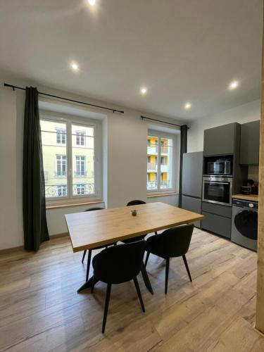 une cuisine et une salle à manger avec une table et des chaises en bois dans l'établissement Appartement entier F2 - Moderne - Jean Jaurès, à Saint-Étienne