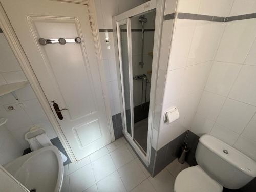 a white bathroom with a shower and a toilet at Jazmines 5 in Denia