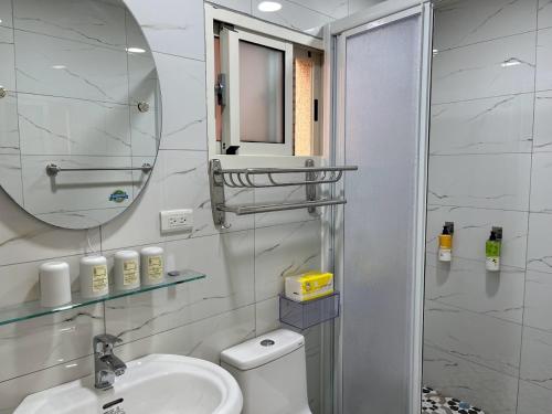 a bathroom with a toilet and a sink and a mirror at Sky south in Xiaoliuqiu