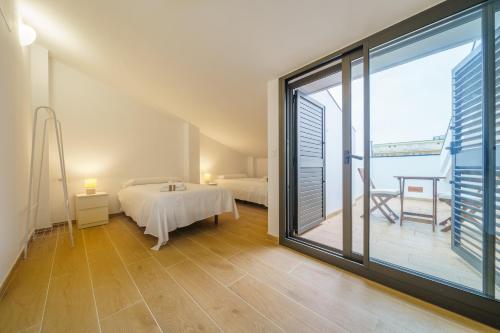 ein Schlafzimmer mit einem Bett und einem großen Fenster in der Unterkunft HomeHolidaysRentals Zen - Costa Barcelona in Pineda de Mar