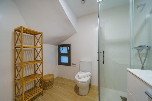 ein Bad mit einem WC und einer Glasdusche in der Unterkunft HomeHolidaysRentals Zen - Costa Barcelona in Pineda de Mar