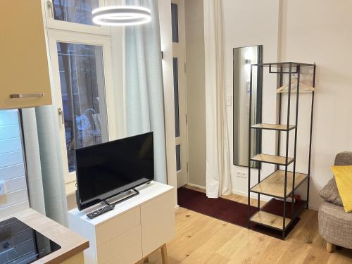 a living room with a flat screen tv on a white cabinet at Ferienwohnung Berlin Mitte in Berlin