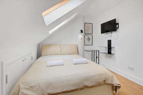 ein Schlafzimmer mit einem Bett mit zwei Handtüchern darauf in der Unterkunft Quality Apartments Close to Tube in Hendon