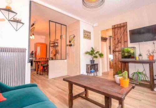 un salon avec un canapé et une table dans l'établissement Les Valéricaines Appartement Vieille Ville Saint Valery sur Somme, à Saint-Valery-sur-Somme