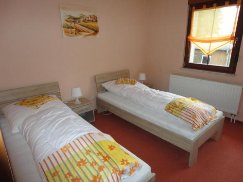 dos camas sentadas una al lado de la otra en una habitación en Ferienwohnung Rochlitzer Berg Blick, 