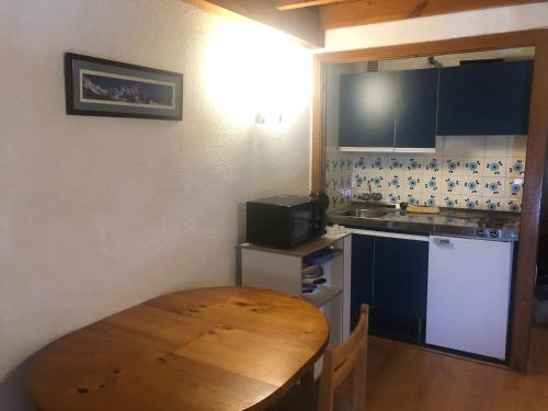 a small kitchen with a wooden table and a kitchen counter at DUPLEX ALCAZABA con parking gratuito, 2 dormitorios , 5pax in Sierra Nevada