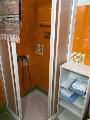 a bathroom with orange tiles and a shower with towels at Céntrico Rota Beach. in Rota