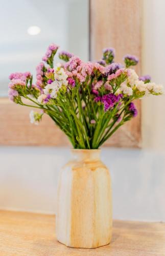 a vase filled with purple and white flowers on a table at LOVE beach club Koh Samui in Chaweng