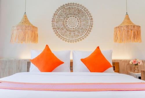 a bedroom with a white bed with orange pillows at LOVE beach club Koh Samui in Chaweng