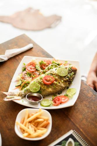 a plate of fish and french fries on a table at Relax Beach House in Tangalle