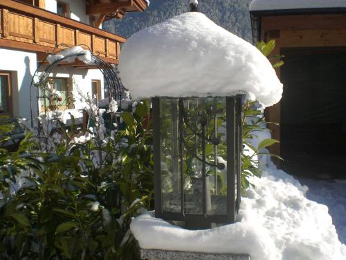 een met sneeuw bedekte lamp in een tuin met sneeuw erop bij Appartements Agnes in Fulpmes
