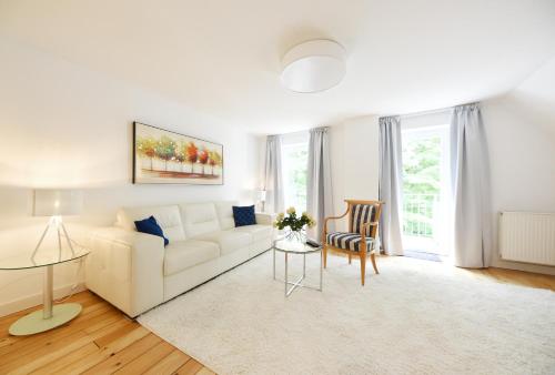 a living room with a white couch and a table at Hotel Restaurant Sengscheider Hof in Sankt Ingbert