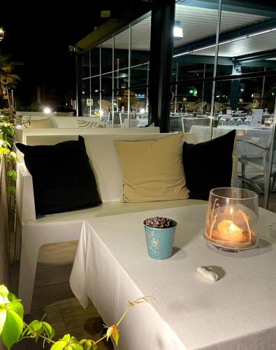 une table blanche avec une bougie sur un chiffon de table blanc dans l'établissement Studio 28 m2 PORTICCIO Centre, à Porticcio