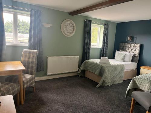 a bedroom with a bed and a table and chairs at Alexander Park B&B in Ledbury