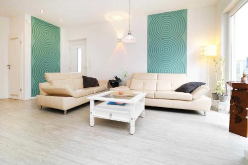 a living room with two couches and a coffee table at Ferienwohnung Wiesenglueck_EHRL in Ostseebad Karlshagen