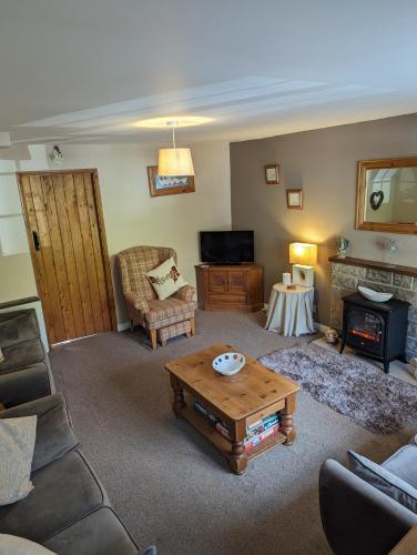 a living room with a couch and a coffee table at Jasmine Cottage Lastingham North Yorkshire in Lastingham