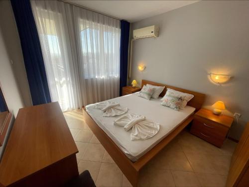 1 dormitorio con 1 cama con toallas en Sunny Beach Hills - Menada Apartments en Sunny Beach