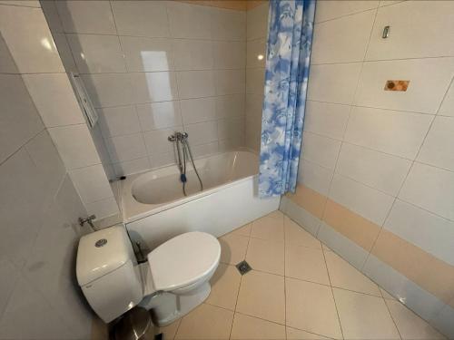 a bathroom with a toilet and a bath tub at Sunny Beach Hills - Menada Apartments in Sunny Beach