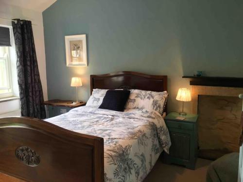 1 dormitorio con 1 cama con 2 mesitas de noche y 2 lámparas en Sanctuary Cottage at Blacko en Barrowford