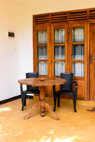a wooden table and chairs in a room at Relax Beach House in Tangalle