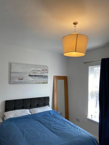 a bedroom with a blue bed and a light at 121 Spring Road in Kempston