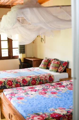 a bedroom with two beds and a canopy bed at Relax Beach House in Tangalle