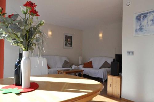 una sala de estar con un jarrón de flores sobre una mesa en Ferienwohnung Wilhelm en Sautens