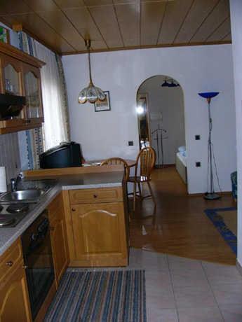a kitchen with wooden cabinets and a dining room at Ferienwohnungen Hauerperle in Neudörfl