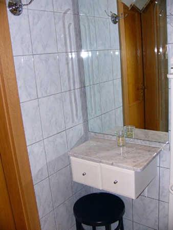 a bathroom with a sink and a mirror and a stool at Ferienwohnungen Hauerperle in Neudörfl
