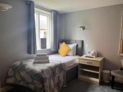 a small bedroom with a bed and a window at Alexander Park B&B in Ledbury