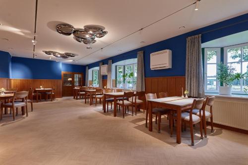 a dining room with tables and chairs and blue walls at Hotel Am Steendamm in Oyten