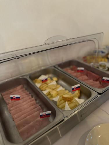 a refrigerator with two trays of meats and cheese at Apartmány Tri sestry Jasná in Demanovska Dolina
