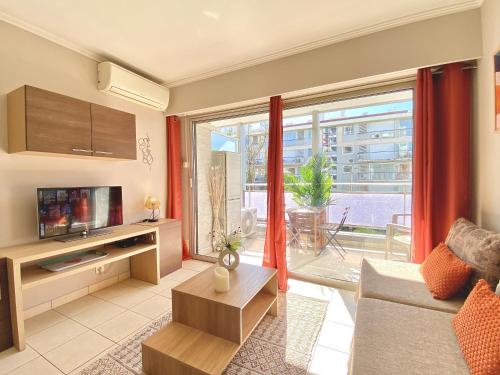 un salon avec un canapé et une grande fenêtre dans l'établissement Terracotta - Proche Palais des Festivals - By SCLS Locations, à Cannes